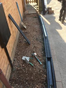 Drainage channels being laid for new tarmac pathway